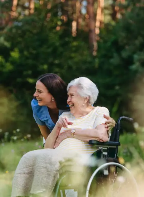 A caregiver with an elderly woman outdoors
